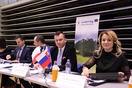 Przy stole siedzi pięć osób. Wśród nich wiceminister Adam Hamryszczak. Za nimi stoi baner Interreg Polska-Słowacja.